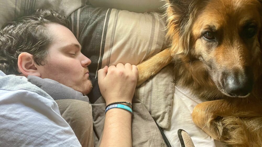 Miles resting at home with his beloved dog, Skye.