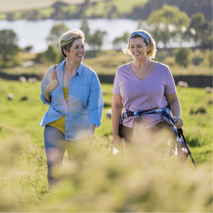 Two women walking in the countryside on a sunny day