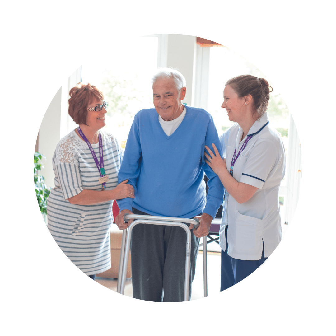 A patient is helped as he uses a support frame