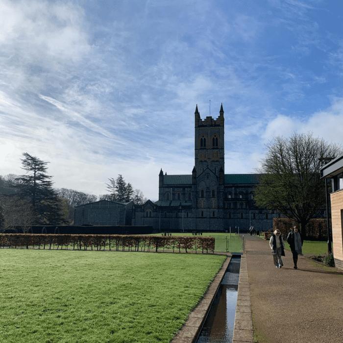 Buckfast Abbey sits in the background against a beautiful blue sky.