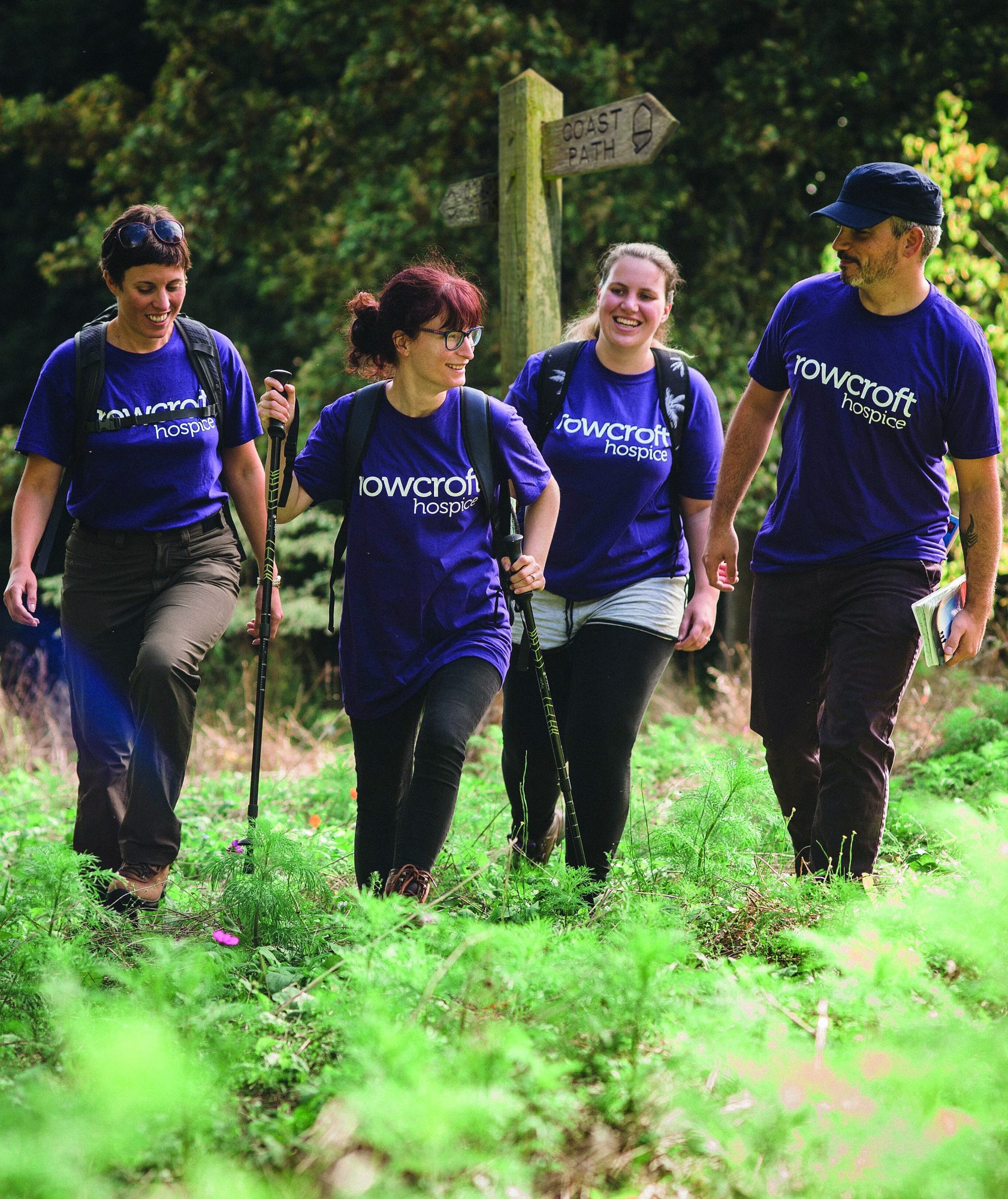 Some Rowcroft fundraisers are seen in purple branded t-shirts with hiking equipment in their hands.