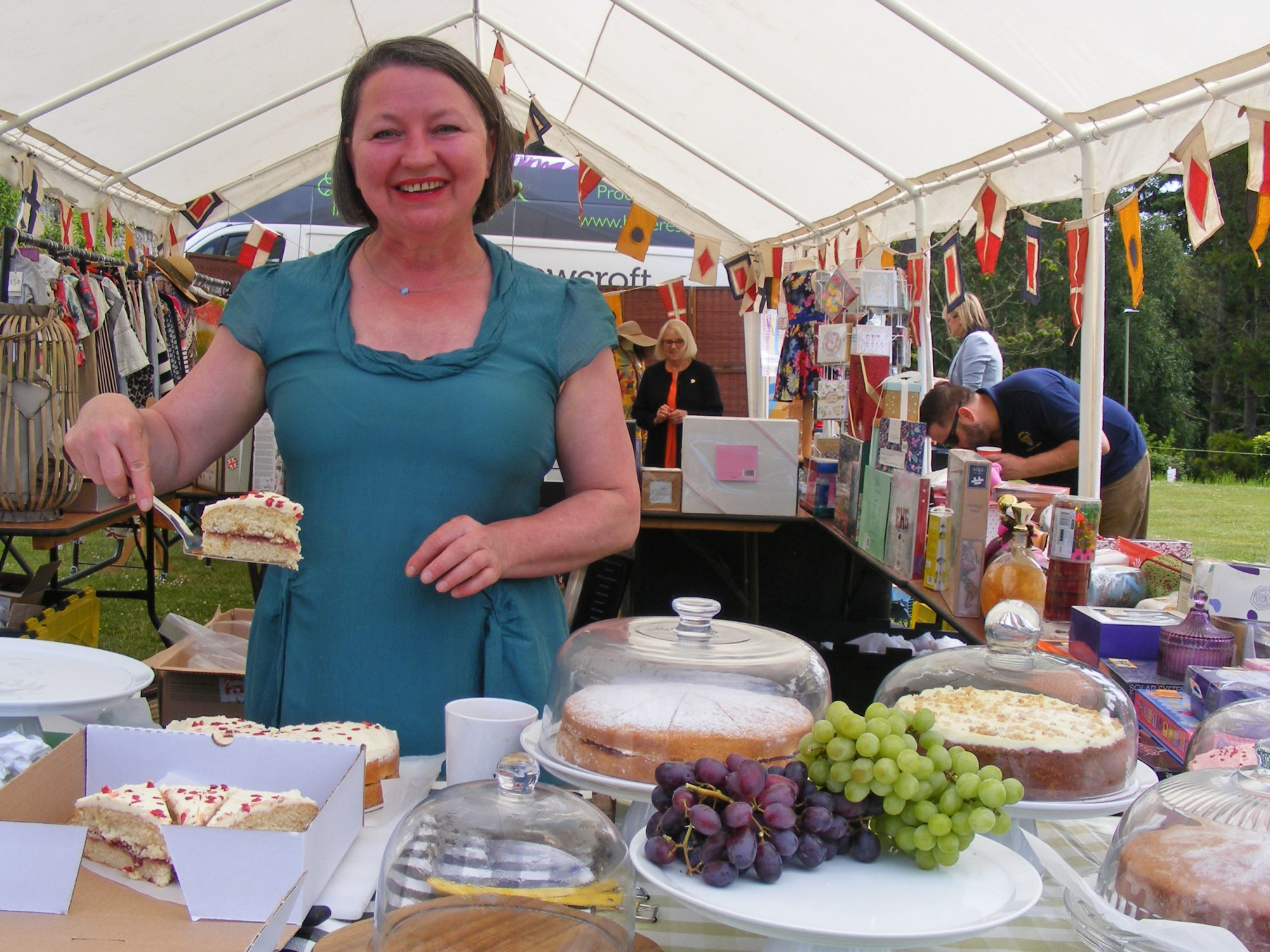Volunteer serves slices of cake at Rowcrofts garden party.