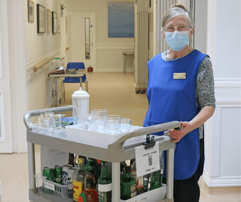 A Rowcroft volunteer stands with the drinks trolley on IPU.