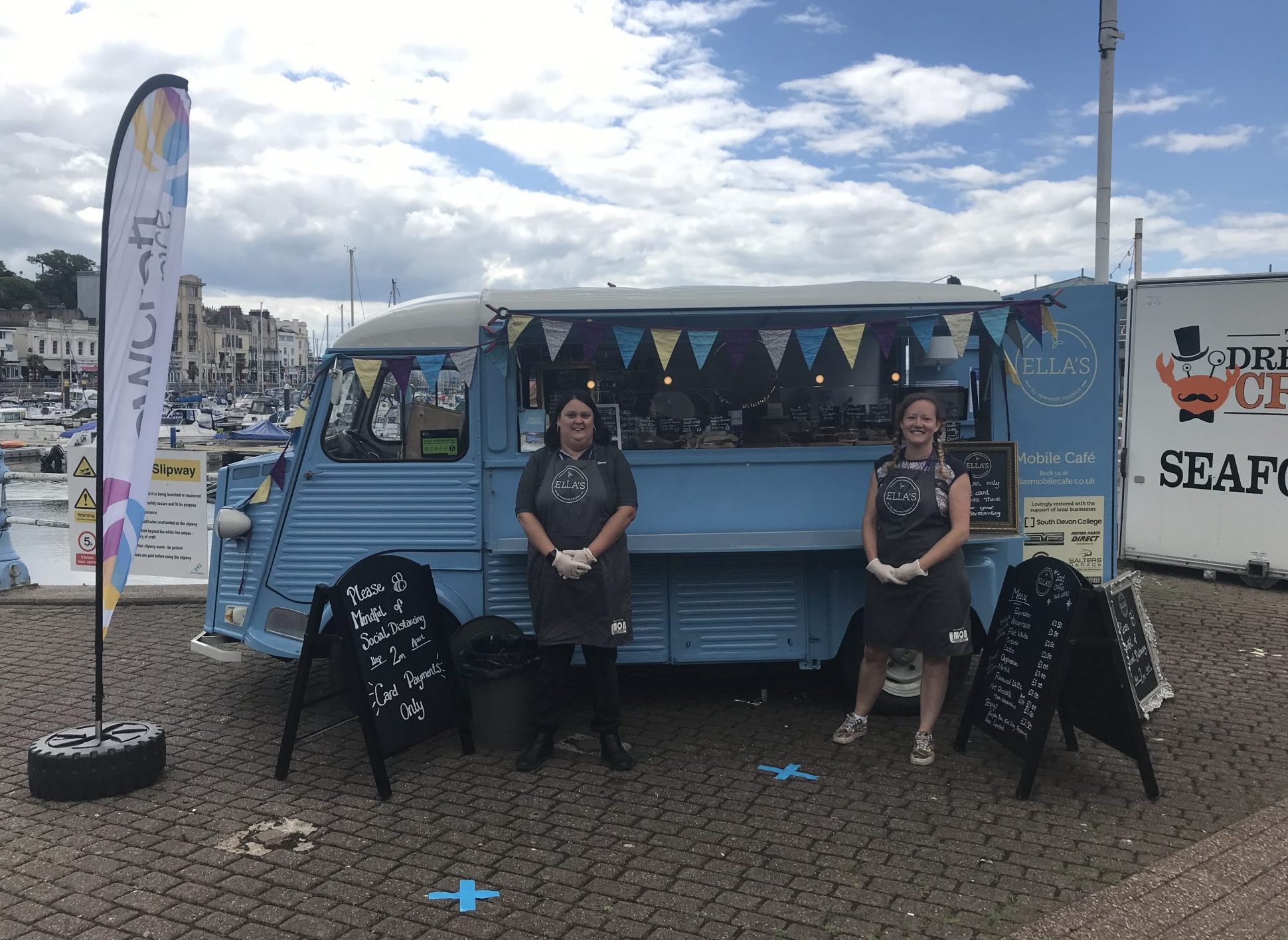 Ella's mobile cafe van and the staff members pose on the harbour.