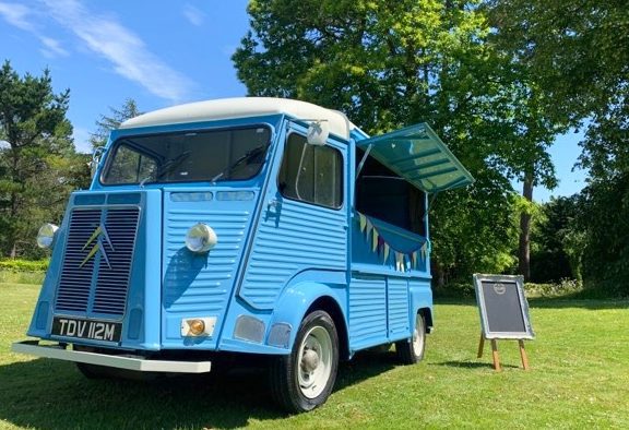 Ella's mobile Café van stands outside in the sun for a photo.