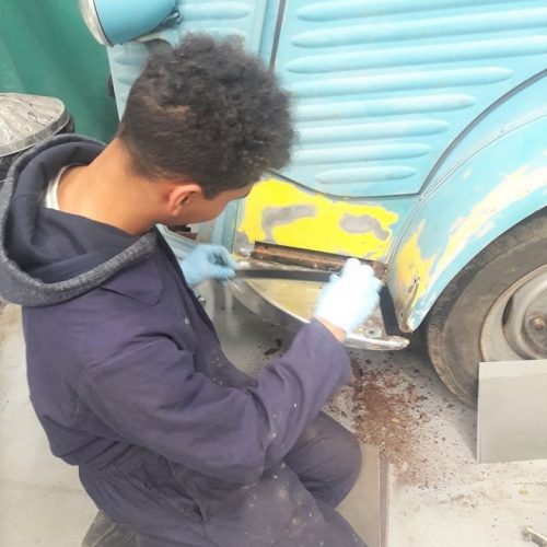 The front of Ella's mobile Café van being renovated by a young man.