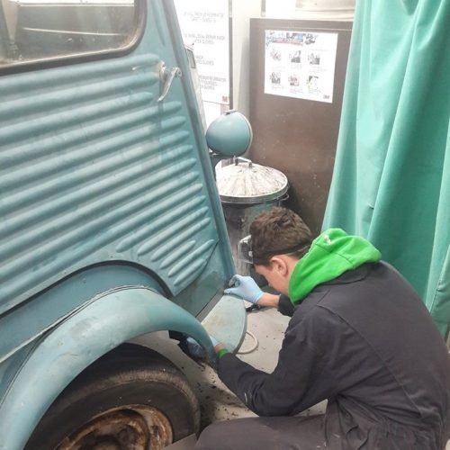 Ella's mobile Café van being built by a person in overalls.