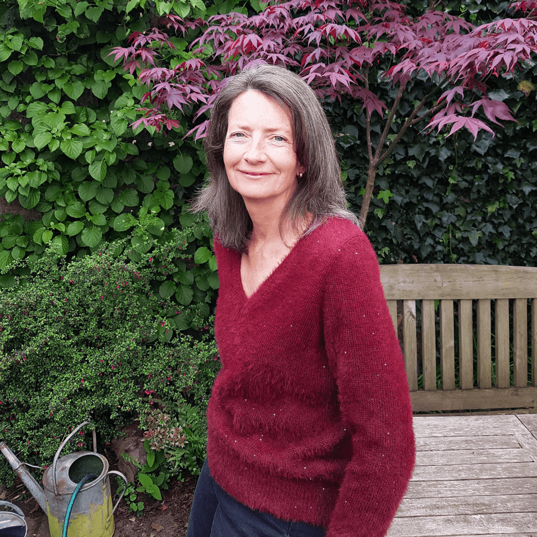 Fiona Ward resting against a bench in a garden
