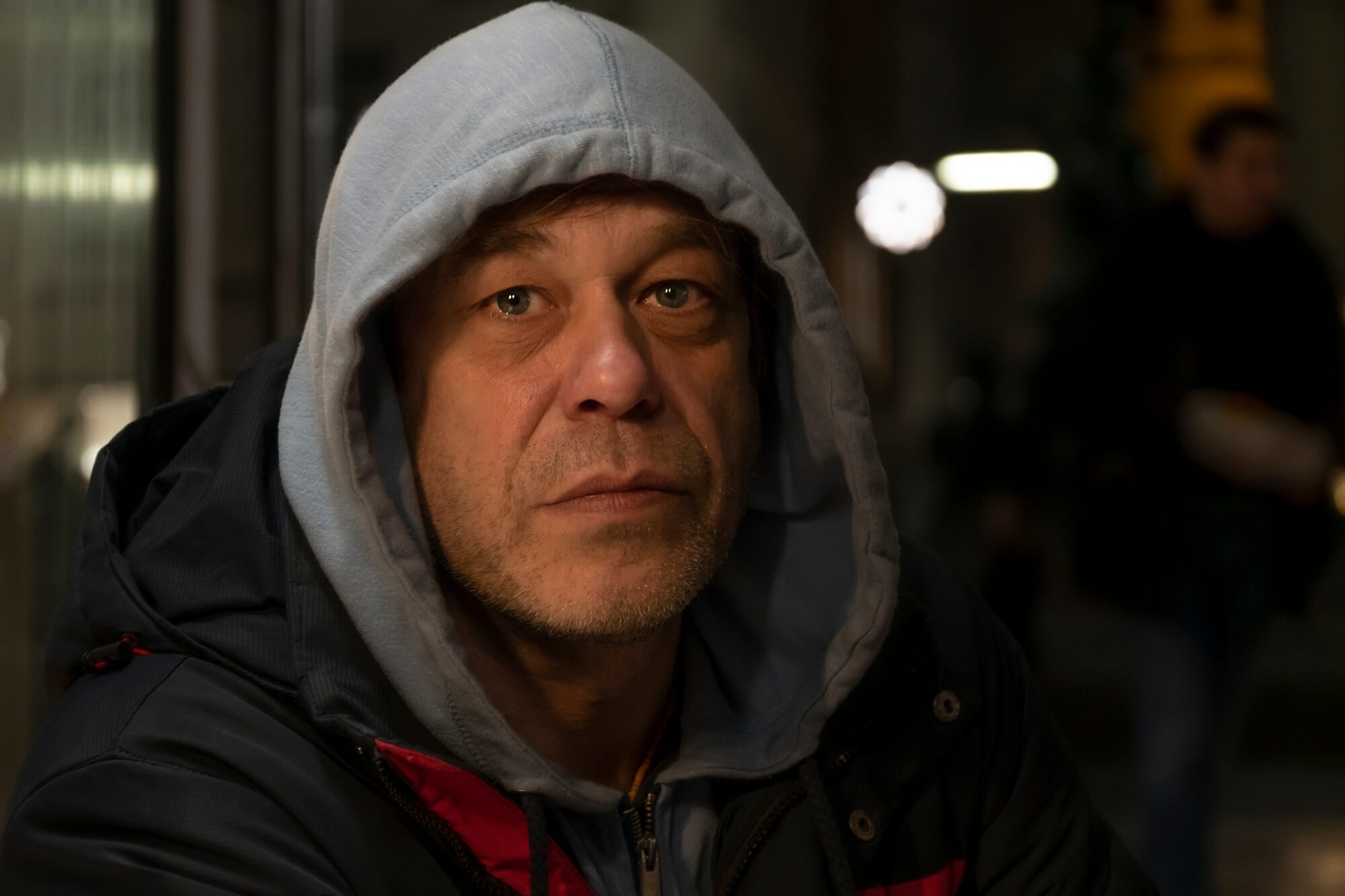 A photo of a man wearing a grey hooded top.