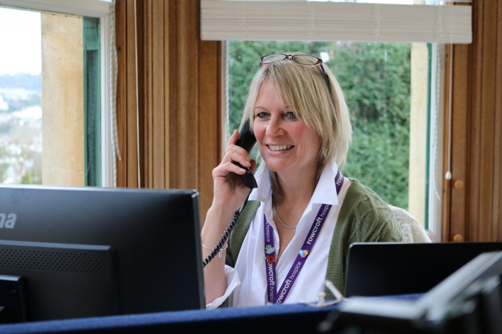 Rebecca Cogger poses with the telephone, she is smiling.