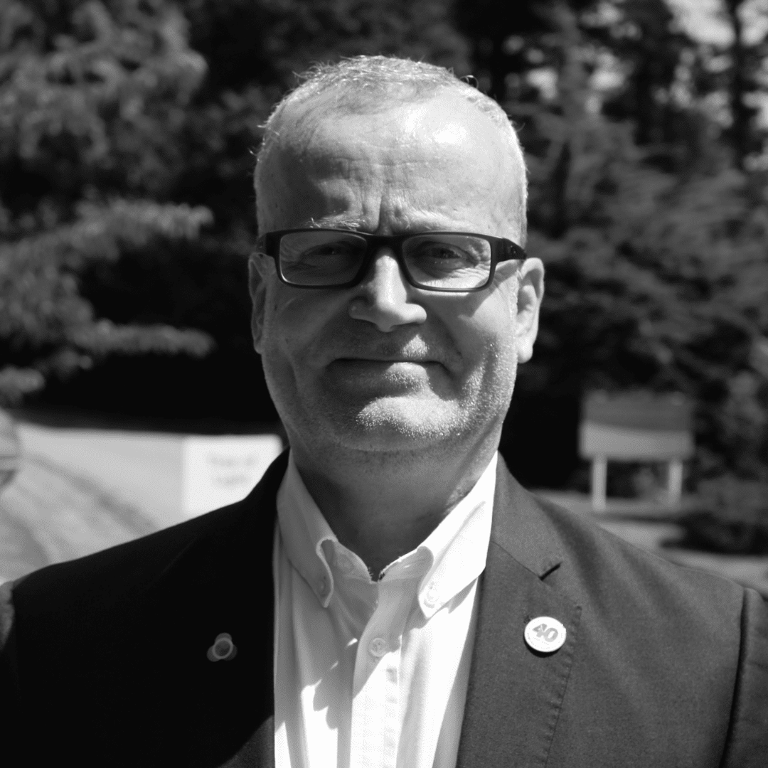 A black and white photo of Mark Hawkins. The image is a close up of his head and shoulders.