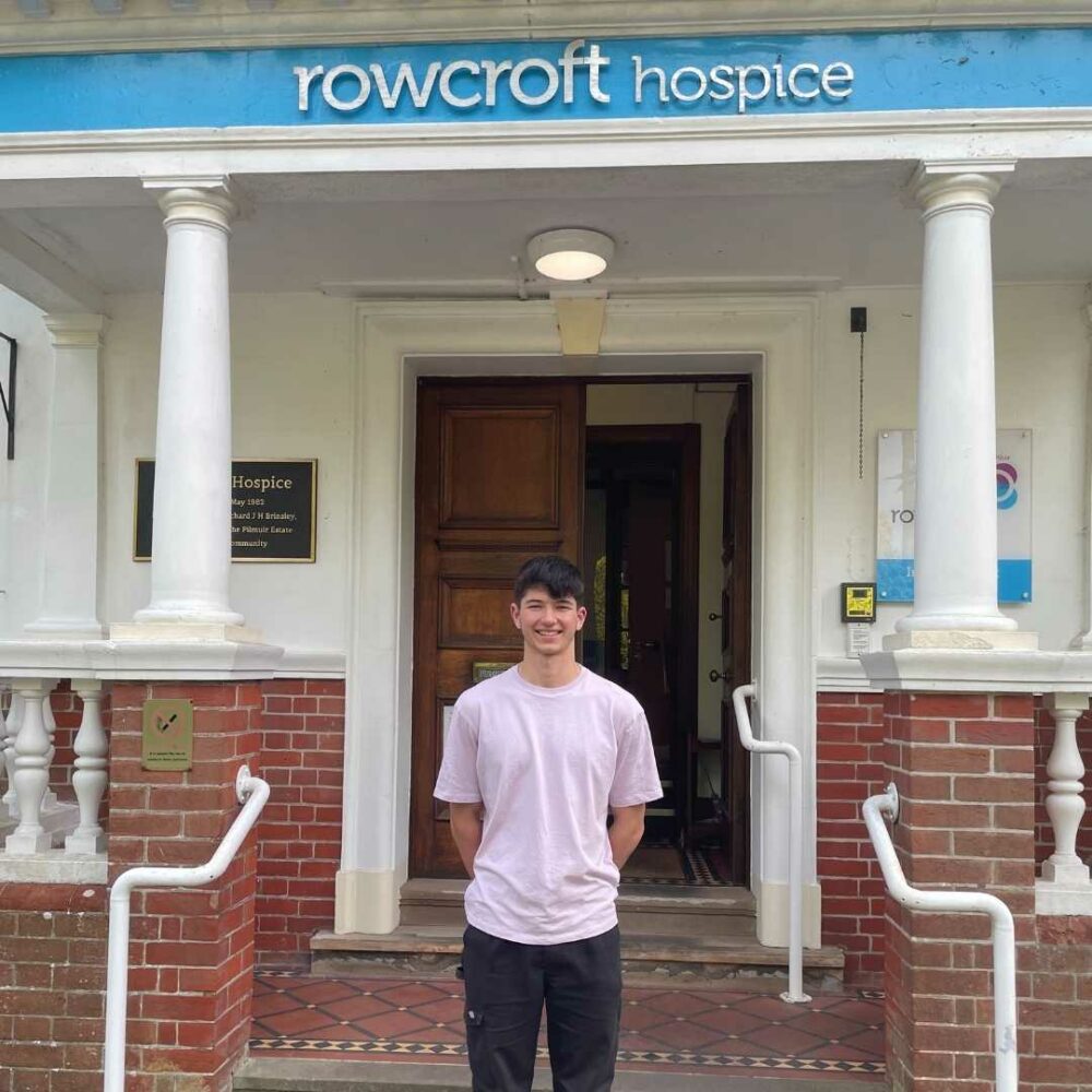 Myles poses at the entranceway to the hospice 