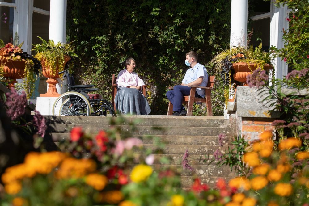 A patient and nurse have a chat in Rowcroft's gardens