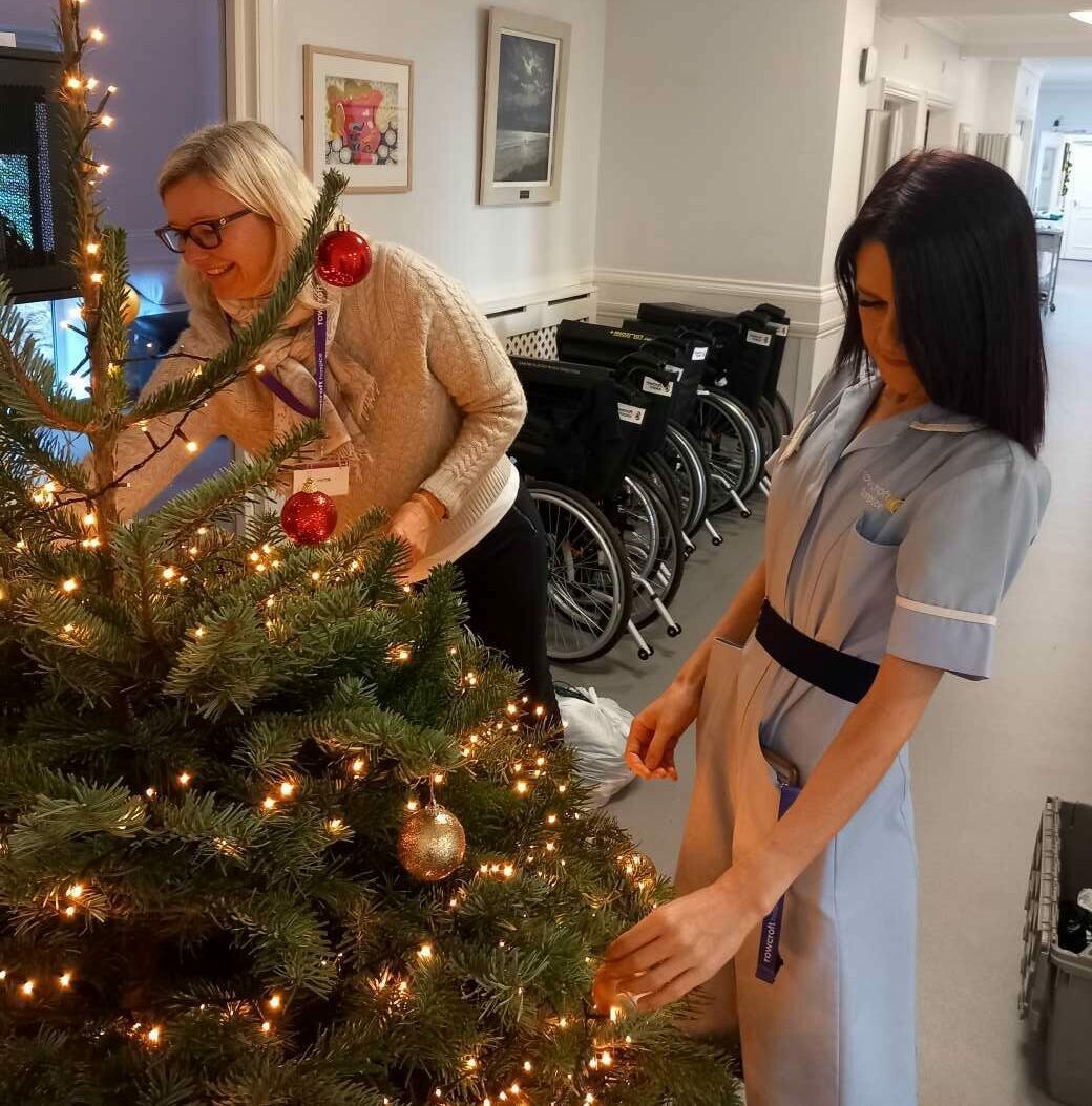 Penny Bailey from Brothwell Irvine at Rowcroft Hospice with Rebecca Macdonald from Rowcroft Hospice decorating Christmas tree in Inpatient Unit