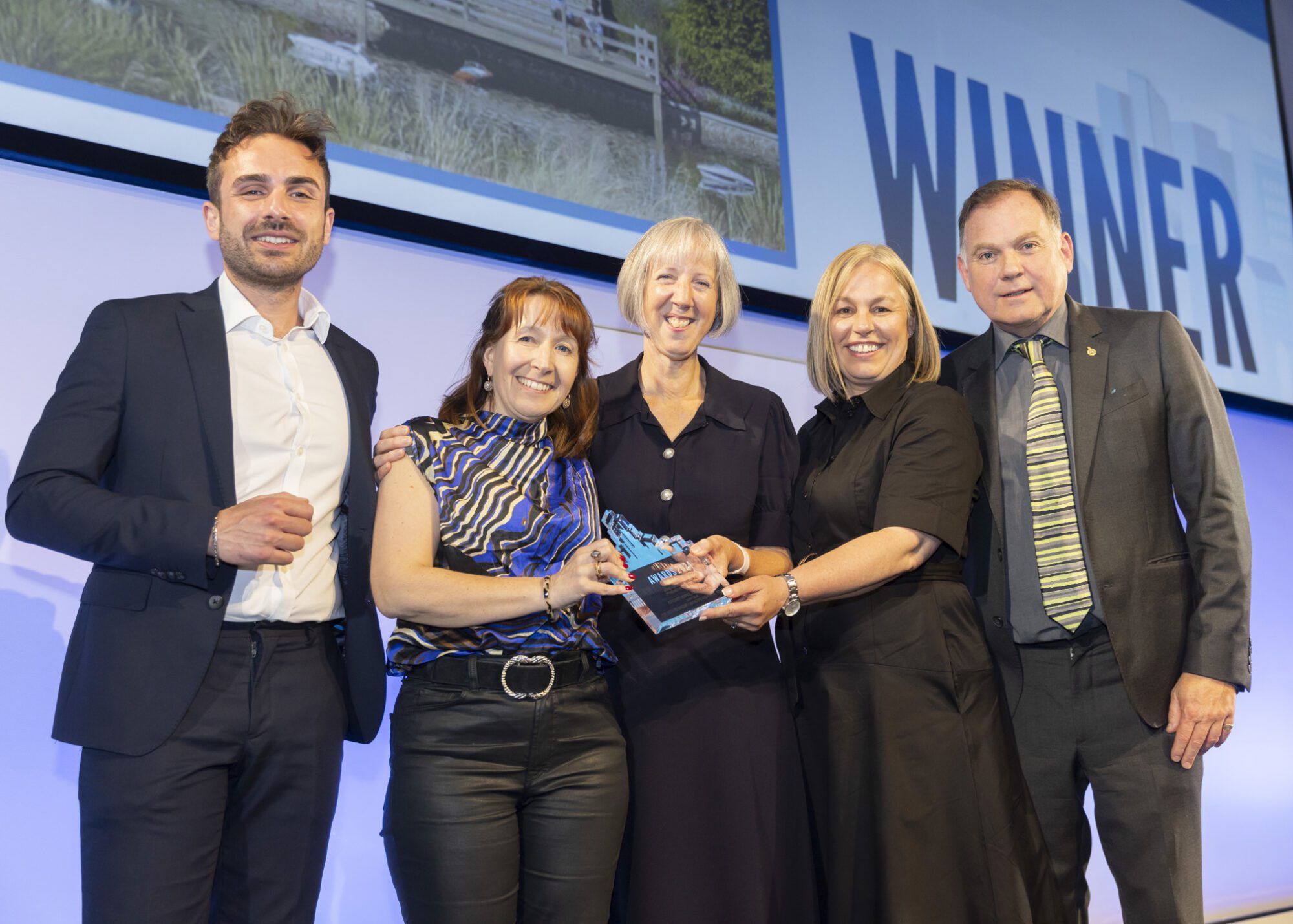 Pictured centre Dr Gill Horne, Programme Director - Care Services, at Rowcroft Hospice, accepts Award for Design Excellence at Planning Awards 2024, with Clare Cameron and Mary Hutchison from PRP.
