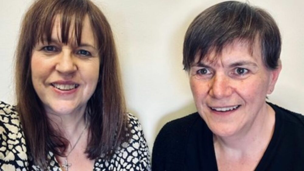 Two learning disability nurses smiling at camera.