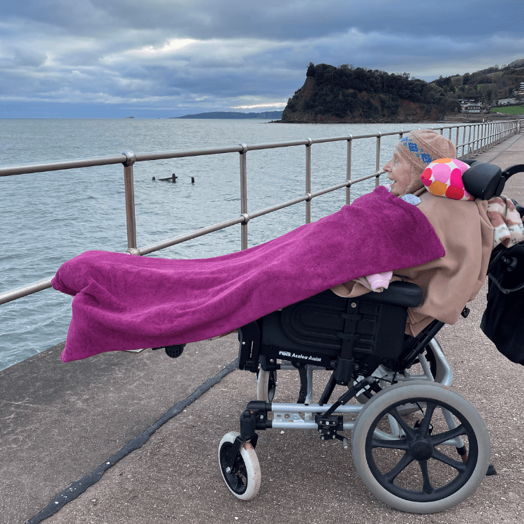 A woman in her wheelchair, admiring the sea at Teignmouth