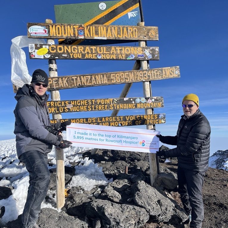 Rowcroft Hospice CEO Mark Hawkins pictured right at top of Mount Kilimanjaro