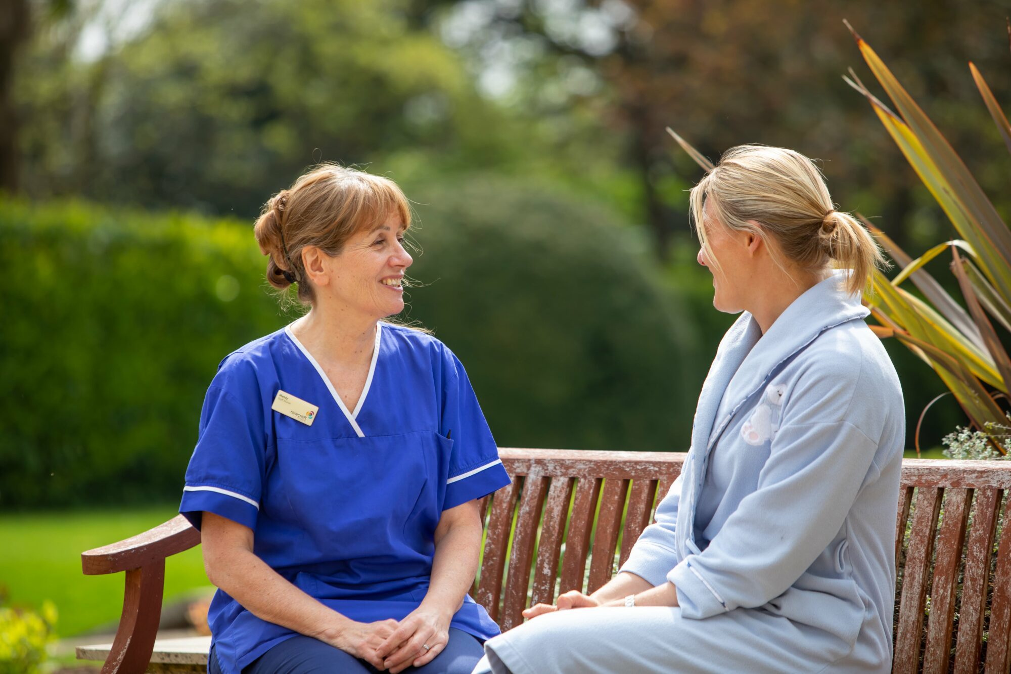 A Rowcroft nurse with a patient in the gardens.
