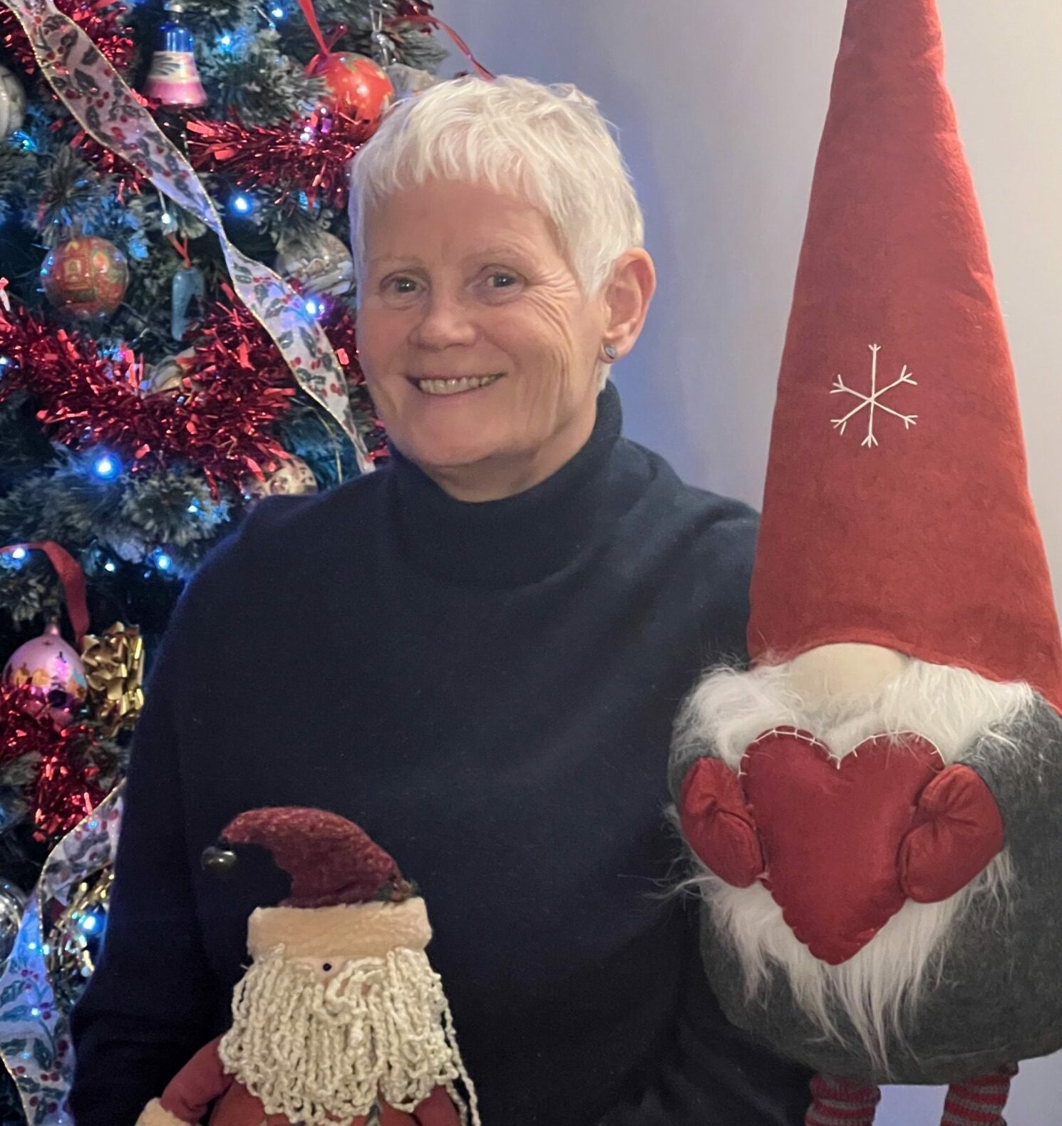 Sally Scott-Bryant poses next top a Christmas tree.
