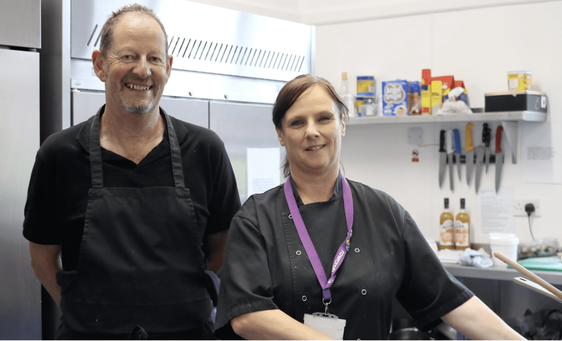 Dave Whiting and Jackie Rowlands smile for a photo in their chefs clothing.