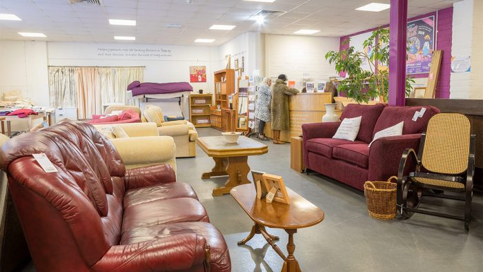 Some red leather sofas and customers paying at the Torquay Furniture Outlet.