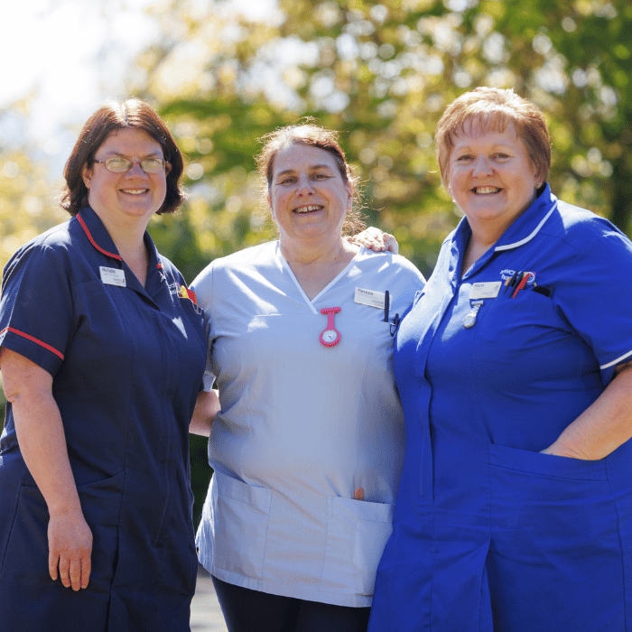 Three Rowcroft nurses together in the grounds of the hospice