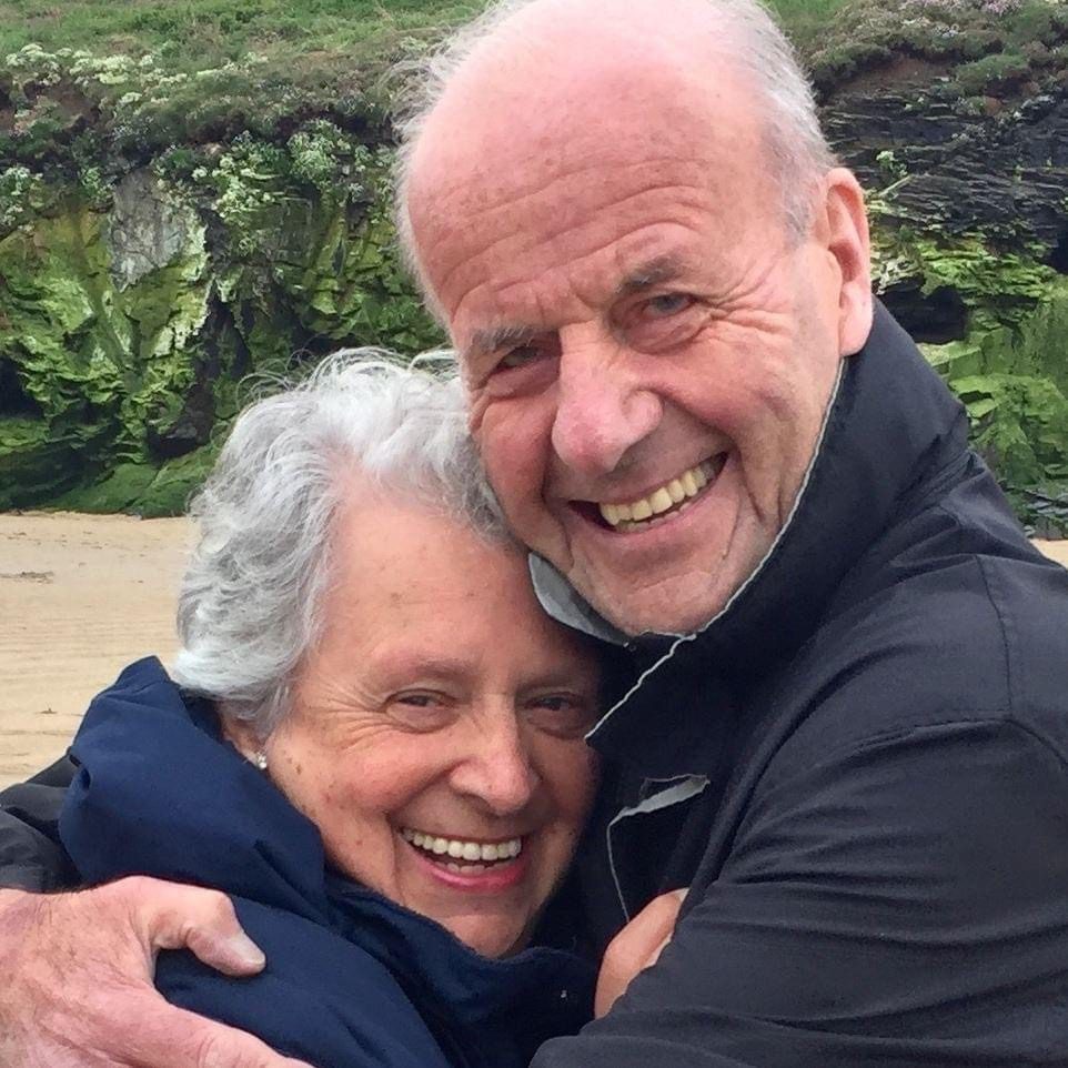 Robert and Shelia Stephenson hug each other on a beach