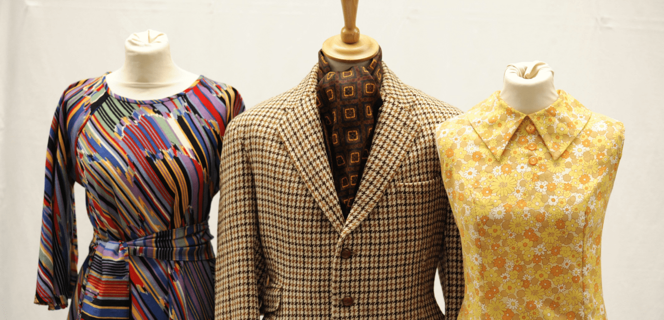 Some 60s inspired clothing on mannikins, such as a tweed blazers and colourful dresses.