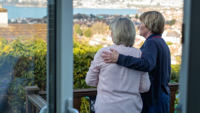 A Rowcroft Hospice at Home nurse stood with a family member looking over Torquay